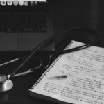 Medical notebook with stethoscope next to a laptop