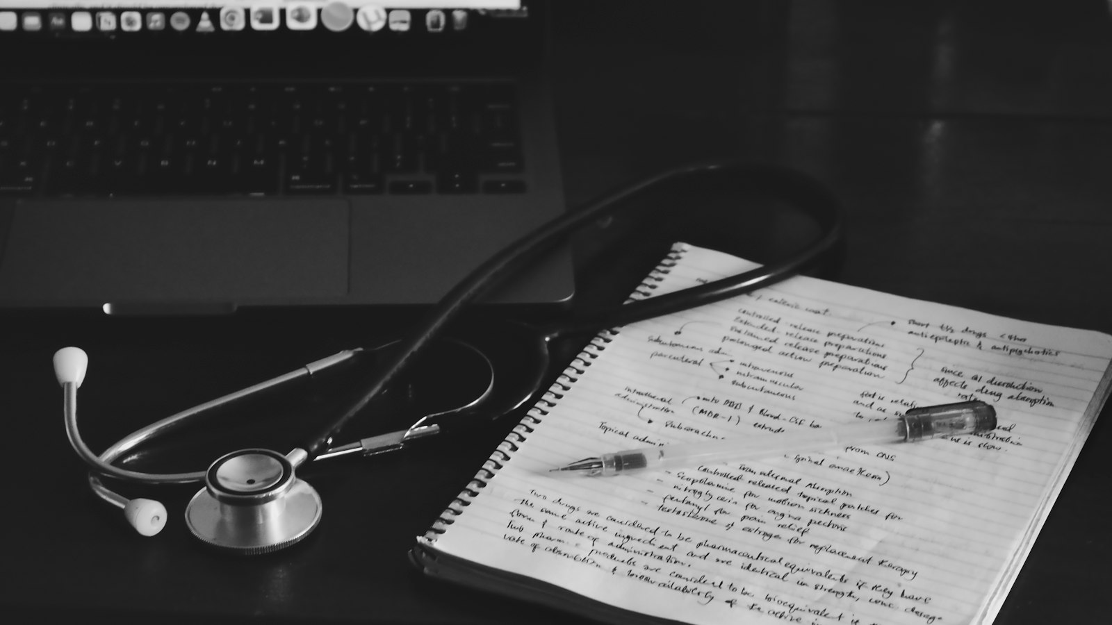 Medical notebook with stethoscope next to a laptop